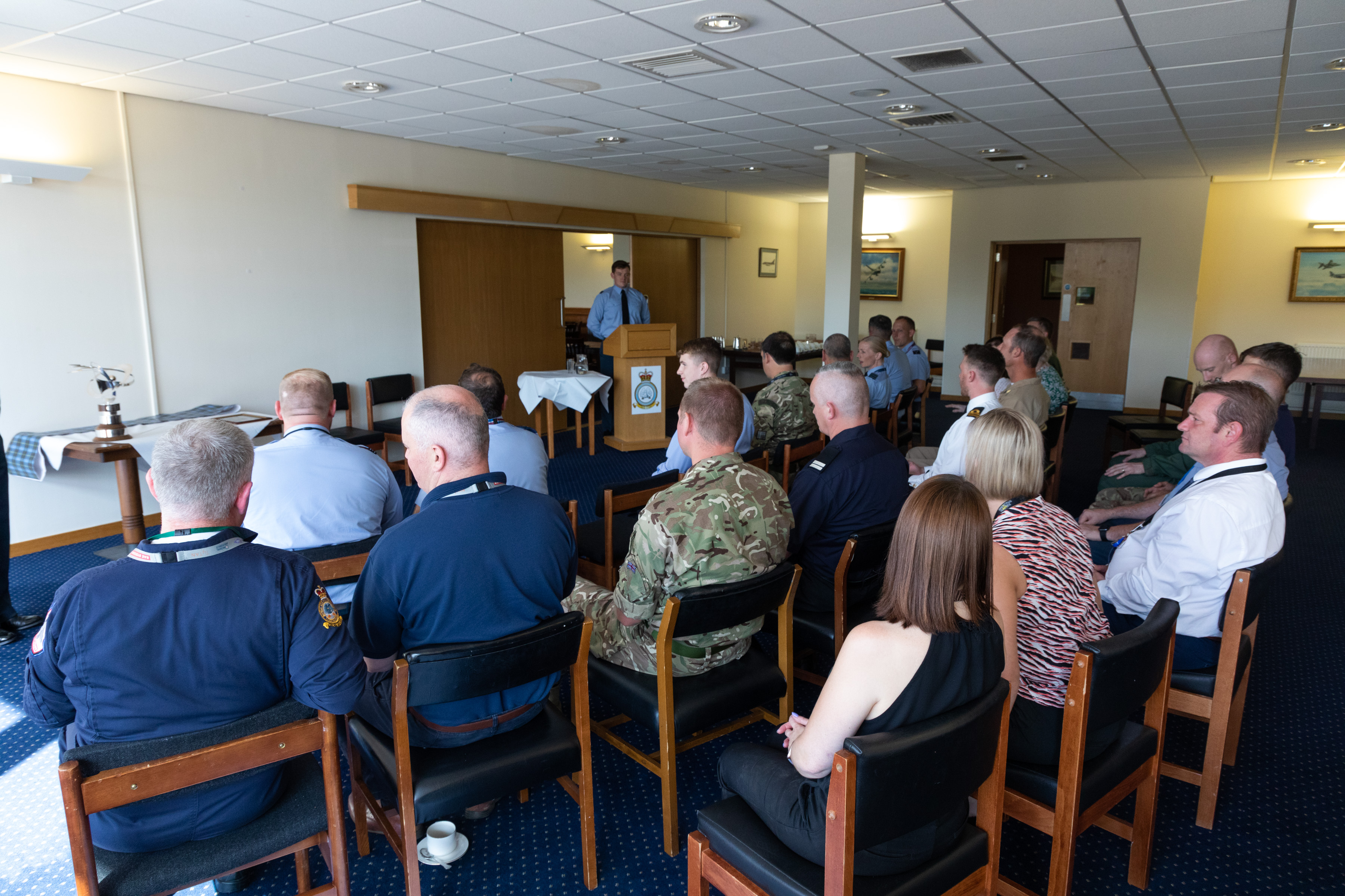 Image shows personnel sitting in the presentation room.